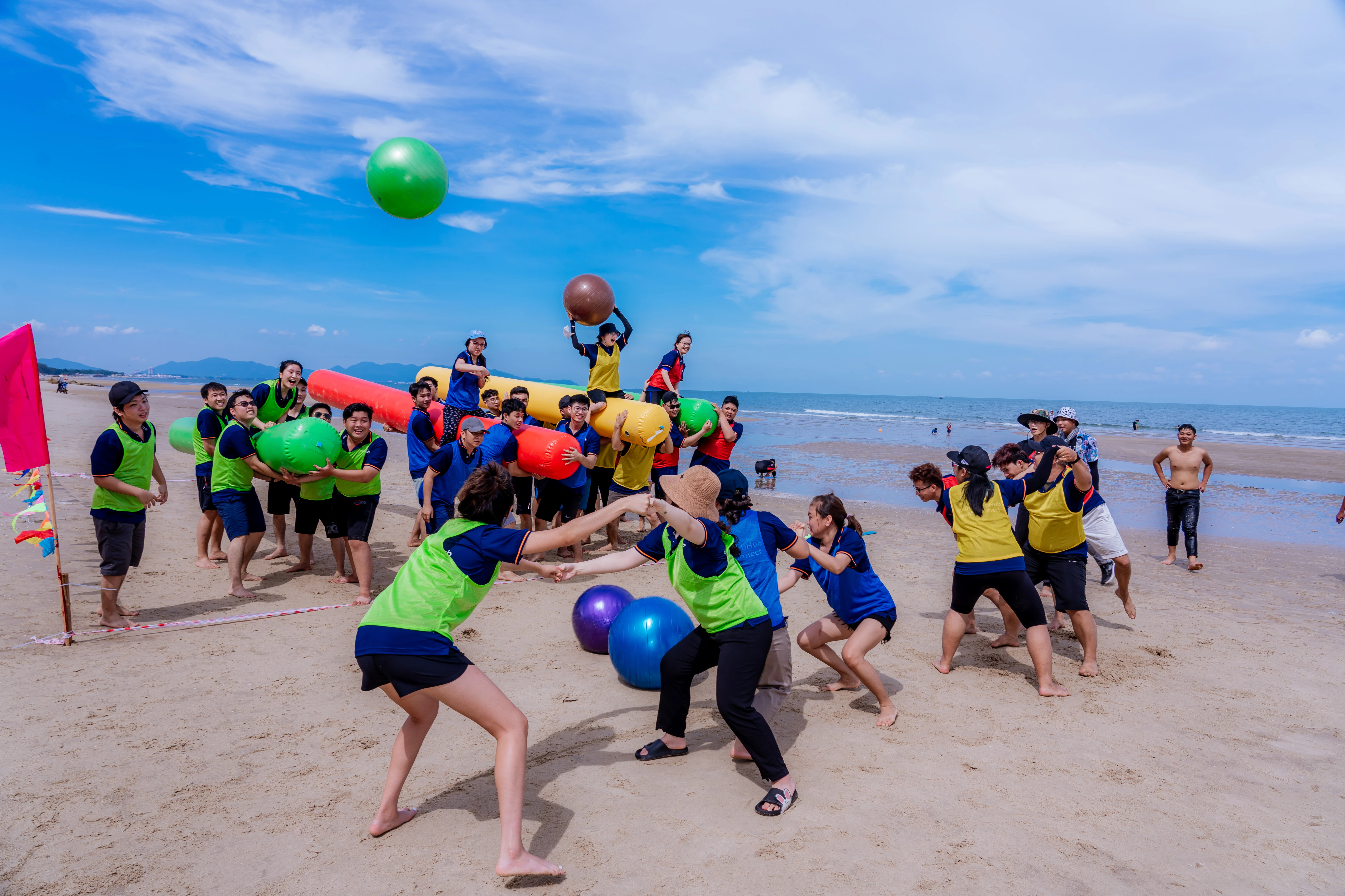 Team challenge of throwing a yoga ball into a human hoop